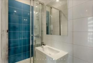 uma casa de banho branca com um lavatório e um espelho em Charmant 2 pièces calme et cosy em Paris