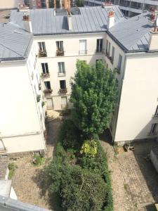 uma vista aérea de um edifício com uma árvore no pátio em Charmant 2 pièces calme et cosy em Paris