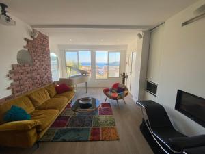 a living room with a couch and a brick wall at La Flibuste des Goudes, maison avec jardins aménagés vue et proche mer au coeur du Parc National du Massif des Calanques in Marseille