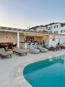a resort with a swimming pool and tables and chairs at Esperides in Platis Yialos Mykonos