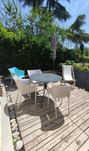 eine Terrasse mit einem Tisch und Stühlen auf einer Holzterrasse in der Unterkunft Studio Golfe Juan, plages, parking, climatisation in Vallauris