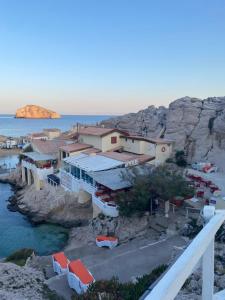 a group of buildings on a cliff next to the water at Parc National des Calanques, LA FLIBUSTE DES GOUDES Maison 2 chambres CLIMATISEE, jardins Jaccuzzi proche plage large vue mer PARKING reserve a l arrivee in Marseille