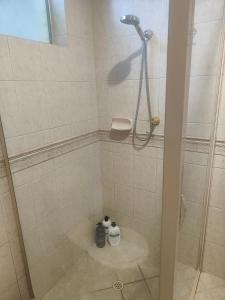 - Baño con cabina de ducha y 2 botellas en The Cozy little House en Armadale