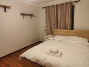 a bedroom with a white bed with a towel on it at The Cozy little House in Armadale