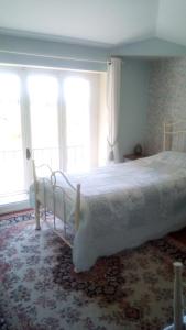 a bedroom with a large bed in a room with windows at Homestay Arrabella in Availles-Limouzine