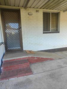 a front door of a house with a brick sidewalk at The Cozy little House in Armadale