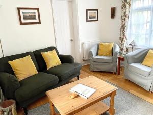 a living room with a couch and two chairs and a table at All Seasons Cottage Breaks in Saxmundham