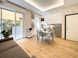 una cucina e un soggiorno con tavolo e sedie di Versilia Residence - Fronte Mare a Lido di Camaiore