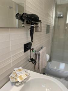 a bathroom sink with a hair dryer on the wall at Scala dei Turchi Palace Suites in Realmonte +42 photos