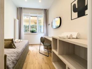 a bedroom with a bed and a desk and a chair at Versilia Residence - Fronte Mare in Lido di Camaiore
