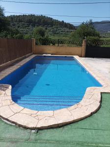 a swimming pool with blue water in a backyard at casas rurales ivan el penas 3 in Letur