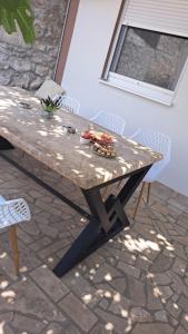 a picnic table on a patio with chairs at Apartman za odmor Peace in Šibenik