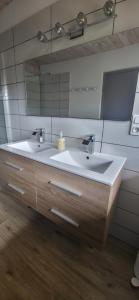 a bathroom with two sinks and a large mirror at La Plante, tendance et design in Ornans