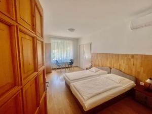 a bedroom with a bed and a table and chairs at Bogoly Apartman in Tokaj
