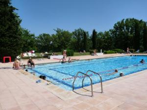 a large swimming pool with people sitting around it at Le Verdon in Gréoux-les-Bains