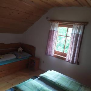 sypialnia z 2 łóżkami i oknem w obiekcie Horná chata u Bratrikov w mieście Haligovce