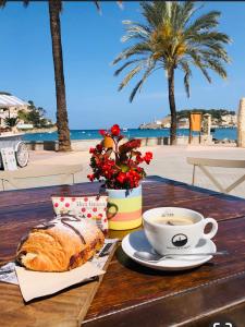 - une table avec un café, un croissant et une tasse de café dans l'établissement Apartaments Platja d’Aro, à Platja d'Aro