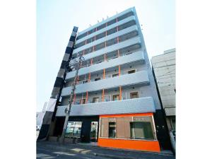 um edifício de tallartment de cor laranja e cinzenta em Hotel AreaOne Kushiro em Kushiro