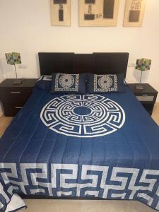 a bed with a blue and white comforter and two lamps at Casa con picina en Granada. in Albolote