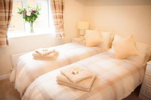 two beds with towels on them in a bedroom at Strathearn Lodge in Auchterarder