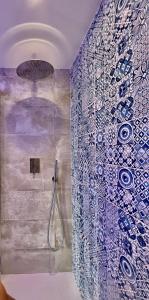 ジョヴィナッツォにあるIl Bugiのバスルーム(青と白のタイル張りのシャワー付)