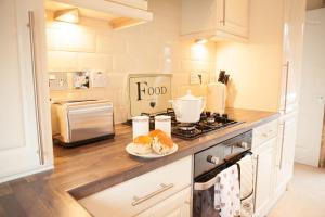 a kitchen with a stove and a plate of food on a counter at Strathearn Lodge in Auchterarder
