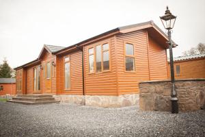 a wooden cabin with a street light in front of it at Strathearn Lodge in Auchterarder