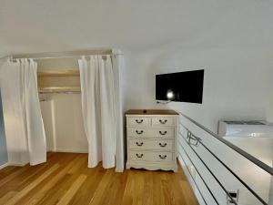 a bedroom with a dresser and a tv on a wall at Il Bugi in Giovinazzo