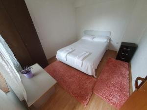 a small bedroom with a bed and two rugs at Apartment Monika in Široki Brijeg