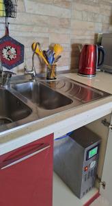 a kitchen counter with a sink and a microwave at Studio Apartment in Durrës