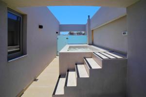 a bathroom with stairs leading up to a bath tub at Heraklion Harbour Penthouse in Heraklio