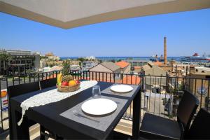 a table on a balcony with a view of the city at Heraklion Harbour Penthouse in Heraklio Town