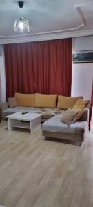 a living room with two beds and a red curtain at Konyaaltı Apart Hotel in Antalya