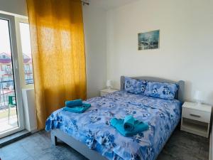 Schlafzimmer mit einem Bett mit blauer Bettwäsche und blauen Handtüchern in der Unterkunft PIERRE 3 la Tarmul MARII -primim Vouchere Vacanta in Costinești