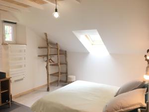um quarto com uma cama e uma clarabóia em Gite du chene em Ledeuix