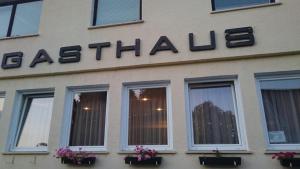 una señal en el lateral de un edificio con ventanas en Gasthaus Teveli, en Kroatisch Geresdorf