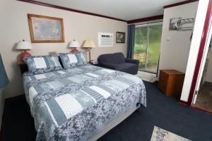 1 dormitorio con 1 cama, 1 silla y 1 ventana en Governor's Rock Motel en Shaftsbury