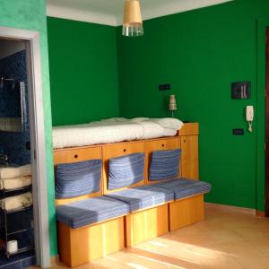 Zimmer mit einer grünen Wand und 2 Etagenbetten in der Unterkunft B&B L’Angolo sulla Piazza in Mirabella Imbaccari