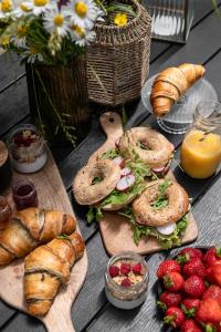 a table topped with sandwiches and croissants and strawberries at ZATORHOUSE in Zator