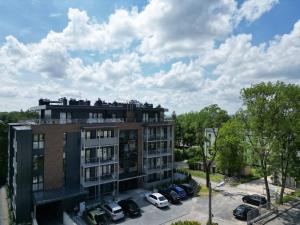 een appartementencomplex met auto's geparkeerd op een parkeerplaats bij Ach to Tu in Busko-Zdrój