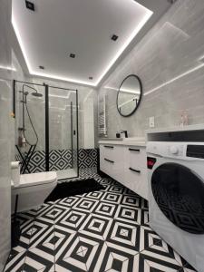 een badkamer met een zwart-witte tegelvloer bij Ach to Tu in Busko-Zdrój