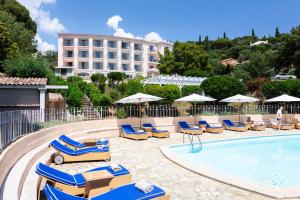 a swimming pool with lounge chairs and a hotel at Hôtel du Parc Cavalaire sur Mer in Cavalaire-sur-Mer