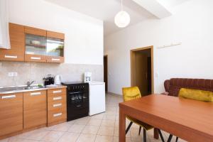 a kitchen with a wooden table and a dining room at Apartments Lonzor in Selce