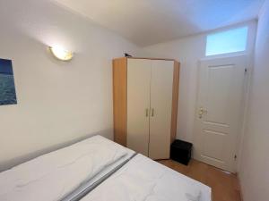 1 dormitorio con 1 cama blanca y armario en Ferienpark Sierksdorf App 537 - Strandlage, en Sierksdorf