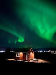 a cabin with the aurora in the sky at Sun-cottage South Iceland in Ölfus