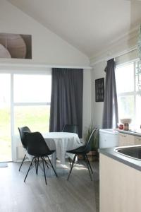 uma cozinha com mesa e cadeiras num quarto em Sun-cottage South Iceland em Ölfus
