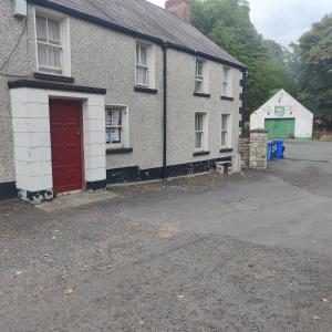 a house with a red door on a street at Lovely 4-bed property in Mullaghbawn in Meigh