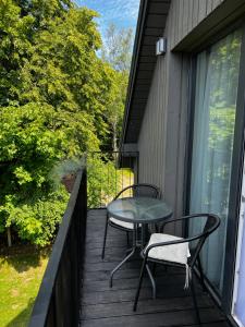 a patio with two chairs and a table on a balcony at Pajūrio Gintaro namai in Palanga