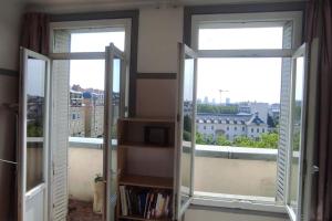 two windows in a room with a view of a city at Logement entier, vue, Paris centre, Catacombes in Paris