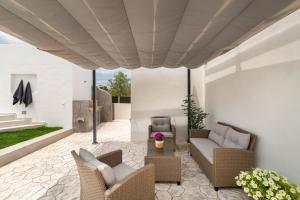 a patio with wicker chairs and a table at Van Loui's II Place in Áyioi